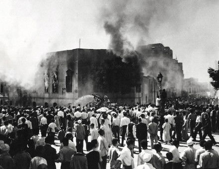 Crowds gather around the burning headquarters of the Muslim Brotherhood in Cairo, 27 October 1954.  It was set on fire after the attempted assassination of Gamal Abdel Nasser. Associated Press/Alamy.
