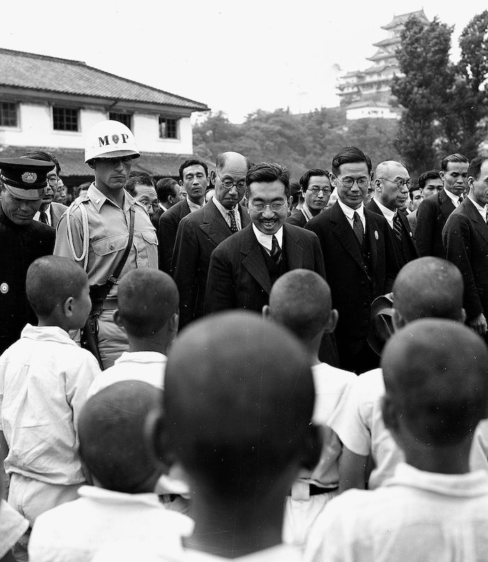 Emperor Hirohito, accompanied by Lieutenant James West, greets primary school students during a nine-day tour of southern Japan, Himeji, 13 June 1947. Associated Press/Alamy Stock Photo