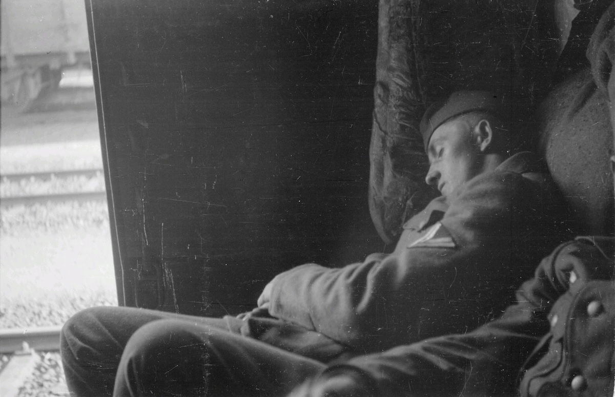 A German soldier sleeps in a railway wagon on his way to the Eastern Front, by Franz Grasser, 1943. Deutsche Fotothek. Public Domain.