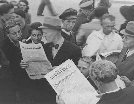 People gather to read a special edition of the Nürnberger newspaper reporting the sentences handed down by the International Military Tribunal, 1 October 1946. US Holocaust Memorial Museum, courtesy of Gerald Schwab.